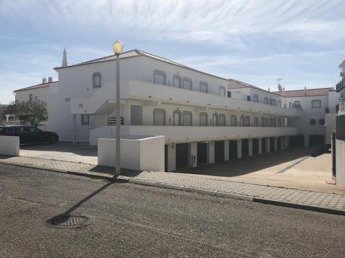 a large white building on the side of a street at Altura da Maré - Apartamento Duna in Altura