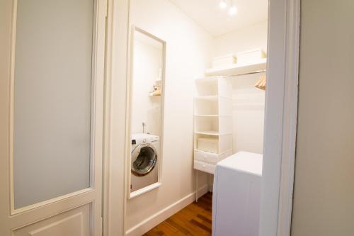 a laundry room with a washing machine and a mirror at Brera Design and Bright Flat in Milan