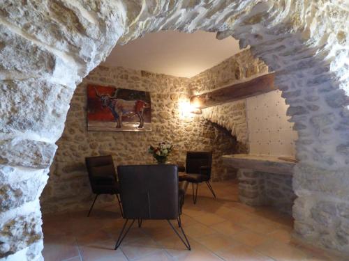 a room with a table and chairs in a stone wall at Mas d'Asvin & Spa in Saint-Christol-lès-Alès
