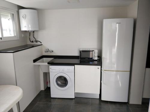 una cocina con nevera y lavadora en Hello Oliva Beach BB, en Oliva