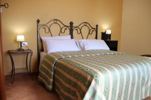 um quarto com uma cama com um edredão verde e branco em Feudo Magazzeni Etna em SantʼAlfio