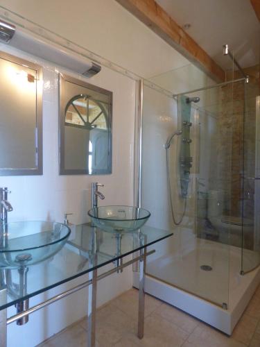 a bathroom with two glass sinks and a shower at Mas d'Asvin & Spa in Saint-Christol-lès-Alès