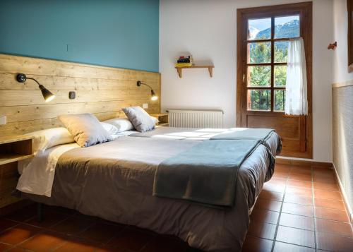 a bedroom with a large bed with a wooden headboard at Hotel de Montaña Uson in Hecho