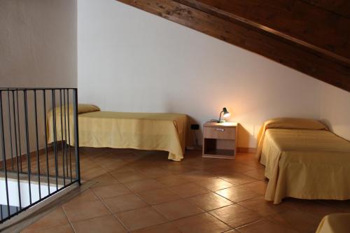 a room with two beds and a table with a lamp at Villa delle Sirene in Ascea
