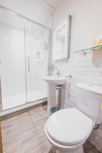 a bathroom with a toilet and a sink and a shower at Kings Arms in Penzance
