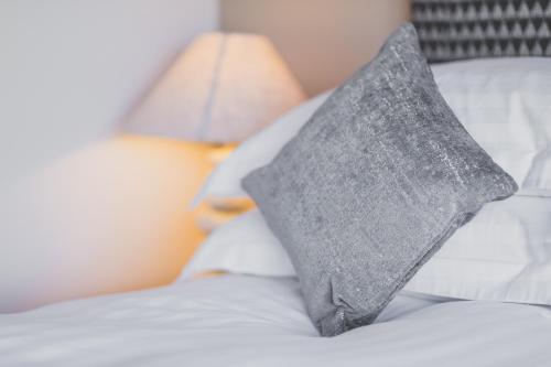 a gray pillow sitting on top of a bed at Kings Arms in Penzance