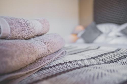 a pile of towels sitting on top of a bed at Kings Arms in Penzance