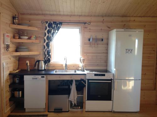 a kitchen with a refrigerator and a sink at Midholl guesthouse in Ásmundarstaðir
