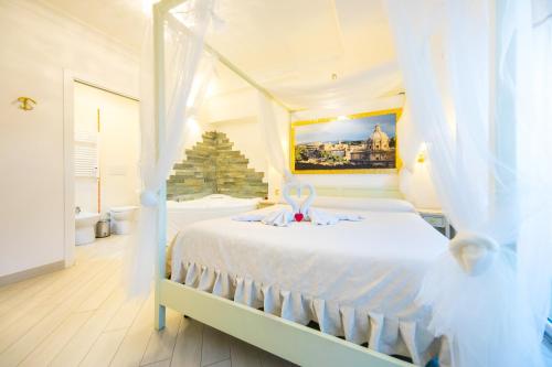 ローマにあるSuites Roma Tiburtina Eleganceのベッドルーム(弓を用いた白いベッド1台付)