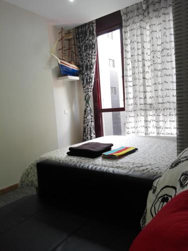 ラスパルマス・デ・グランカナリアにあるPlaya y másの窓付きの部屋のベッド1台