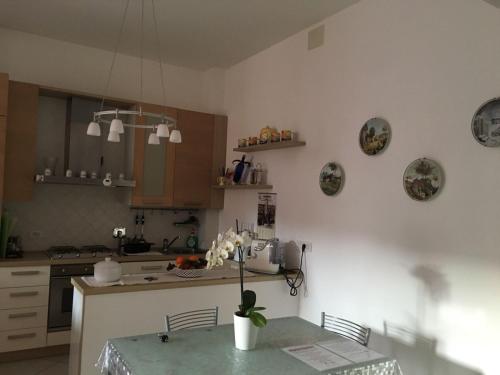 a kitchen with a table with a vase of flowers on it at Una finestra sul mare in Cogoleto