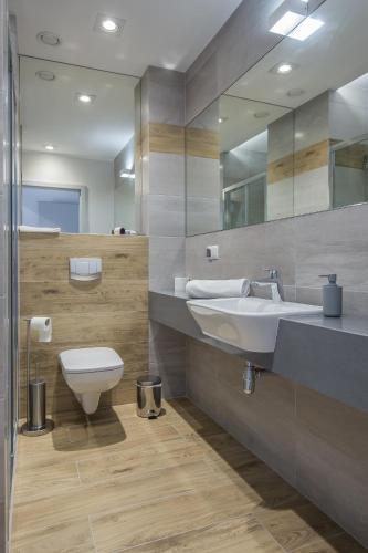 a bathroom with a sink and a toilet and a mirror at Blu Residence in Zielona Góra