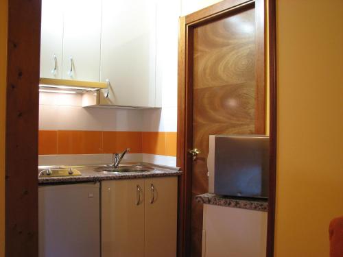 Una pequeña cocina con fregadero y microondas. en Aparthotel Santa Marina, en Cuéllar