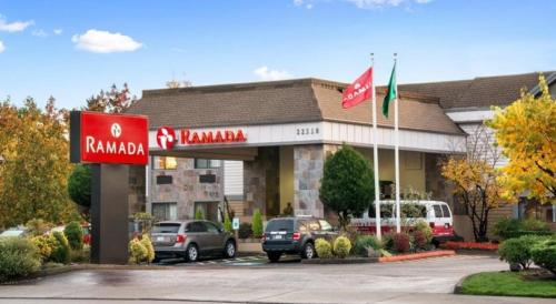 a hotel with cars parked in a parking lot at Ramada by Wyndham Kent Seattle Area in Kent