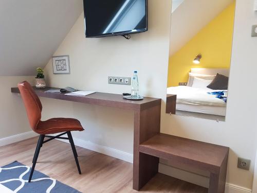 a room with a desk with a bed and a television at Ditlin in Pápa