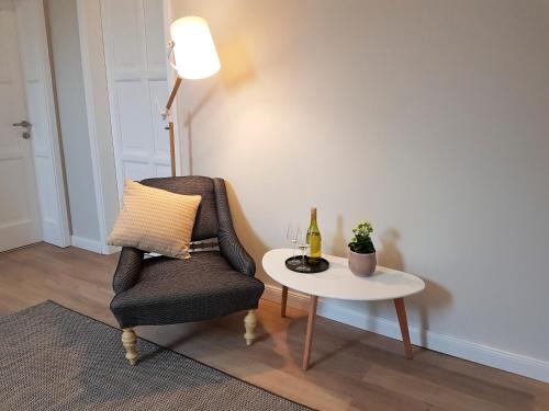a living room with a chair and a table at Ditlin in Pápa