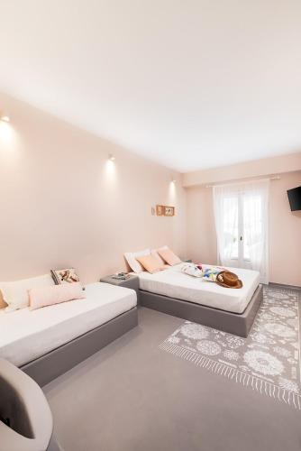 two beds in a room with white walls at Ios Resort in Ios Chora