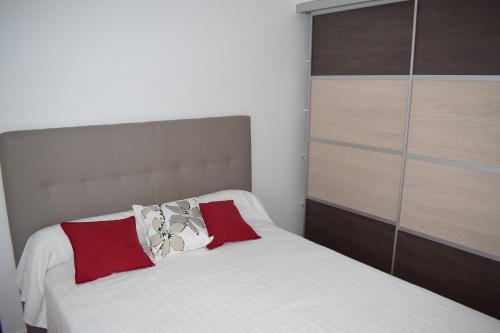 ラ・ロシェルにあるLes 3Mのベッドルーム(白いベッド、赤い枕付)