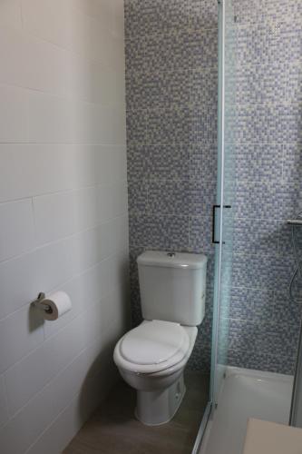 a bathroom with a toilet and a glass shower at HOME4U - Cosy Apartment with Fantastic Terrace in Cabanas de Tavira