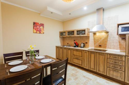 a kitchen with wooden cabinets and a wooden table with chairs at Apartment in Complex Korona on Knyazhyi Zaton 21 in Kyiv