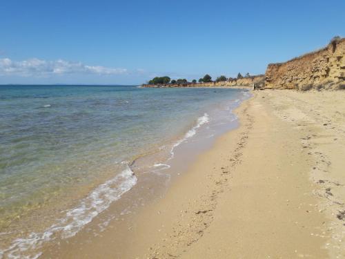 a sandy beach with footprints in the water at Josip in Nin