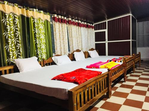 2 aparte bedden in een kamer met gordijnen bij White Clouds Cottage Munnar in Munnar