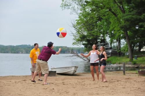 a group of people playing with a ball on the beach at Sunset Bay Resort in Wisconsin Dells