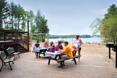 a group of people sitting on a picnic table on the beach at Sunset Bay Resort in Wisconsin Dells