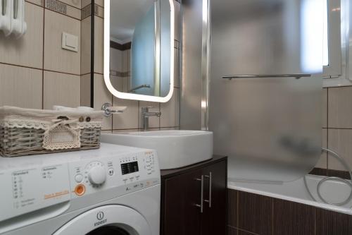 Un baño con lavadora y lavabo. en Absolute Athens III, en Atenas