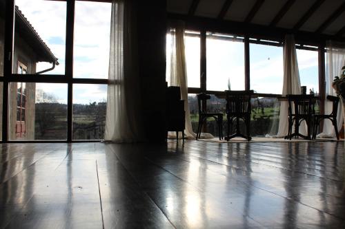 an empty living room with a table and windows at Rectoral de Anllo in Sober