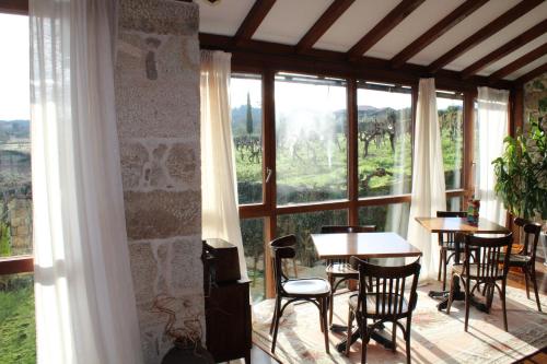 a room with tables and chairs and a large window at Rectoral de Anllo in Sober