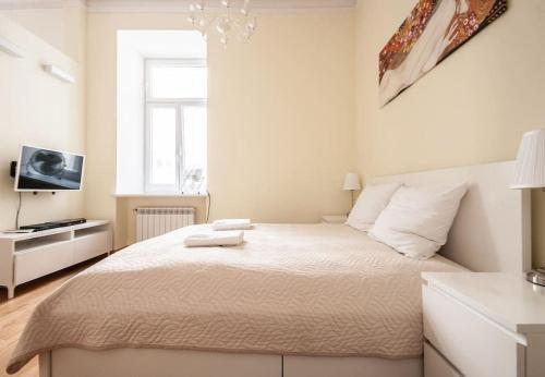 a white bedroom with a bed and a window at Elegant Apartment Foksal in Warsaw