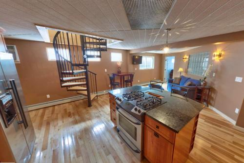 a kitchen with a stove and a staircase in a room at Sands By The Sea Motel in York Beach