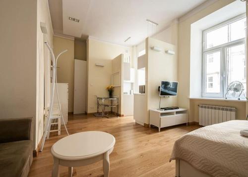 a room with a bed and a table and a television at Elegant Apartment Foksal in Warsaw
