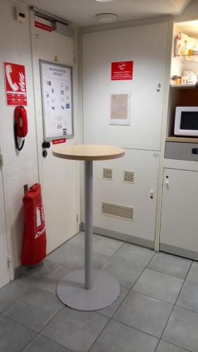 une table dans une cuisine avec un sac rouge dans l'établissement ENZO Hotels 1er PRIX, à Châlons-en-Champagne