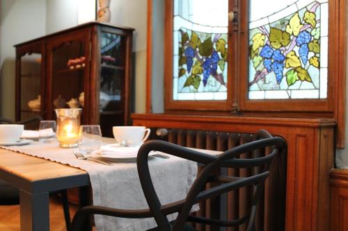 a table with a chair and a stained glass window at Villa Élyane in Colmar