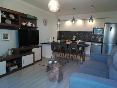a living room with a blue couch and a kitchen at Casas Da Roseira 2+1 Famalicao Nazare in Nazaré