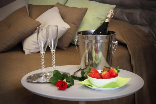 a table with a bottle of wine and a bowl of strawberries at Relais Marlene in Avezzano