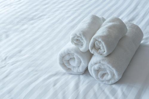 ein Handtuch aus Handtüchern auf dem Bett in der Unterkunft Holiday Inn Express & Suites Corona, an IHG Hotel in Corona