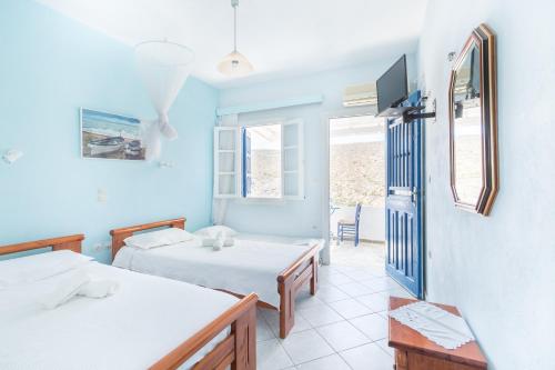 a room with two beds and a tv at Romanza in Cherronisos