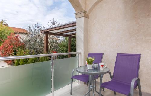 a patio with purple chairs and a table on a balcony at Villa Stephany in Poreč