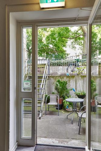 a sliding glass door leading to a patio with a table at Pauli Hostel in Hamburg