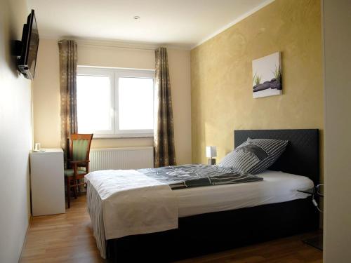 een slaapkamer met een groot bed in een kamer met een raam bij NM-APARTMENTS in Griesheim
