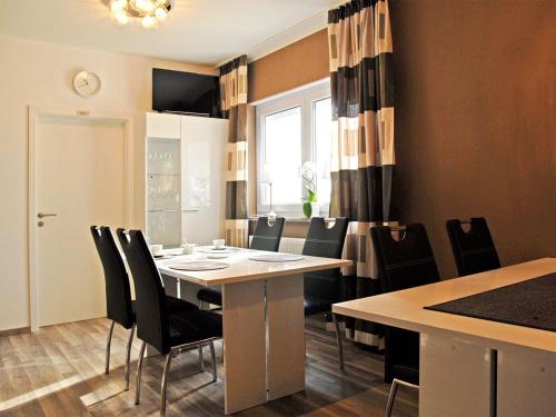 a dining room with a table and black chairs at NM-APARTMENTS in Griesheim