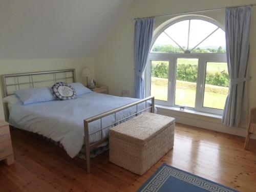 - une chambre avec un lit et une grande fenêtre dans l'établissement Forgefield House, à Kenmare