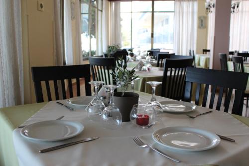 a table with plates and utensils on a white table cloth at Hotel Solon in Tolo