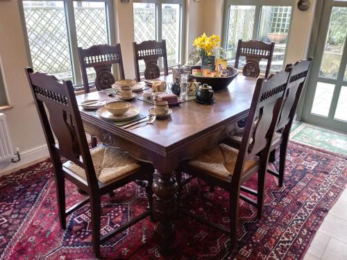 uma mesa de jantar em madeira com cadeiras e uma mesa em Claw House em Holsworthy