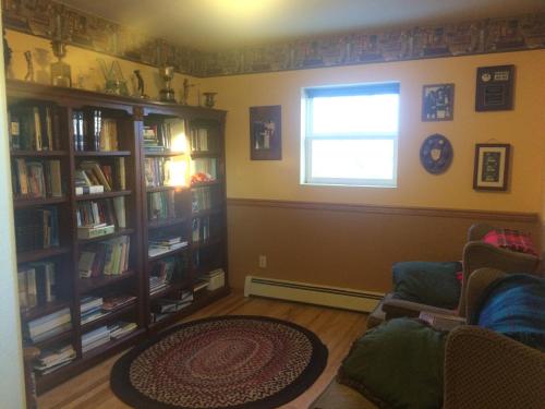 a living room with book shelves and a window at Fishhook Sunrise B&B in Palmer