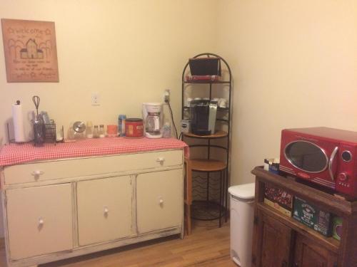 a room with a kitchen with a microwave and a table at Fishhook Sunrise B&B in Palmer
