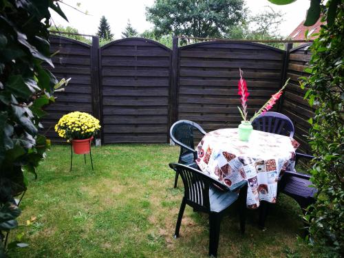 a table and chairs in a backyard with a fence at Ferienwohnung Müller in Sukow